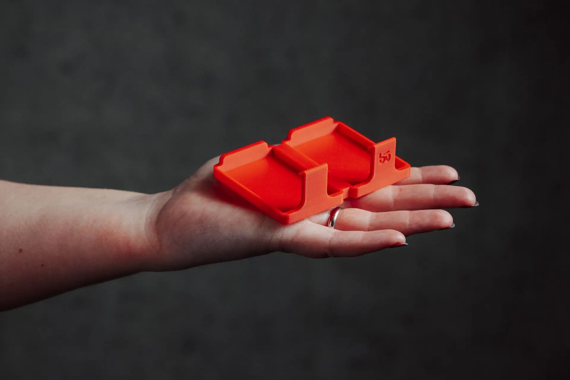 A hand holding an empty Hōld Duo model