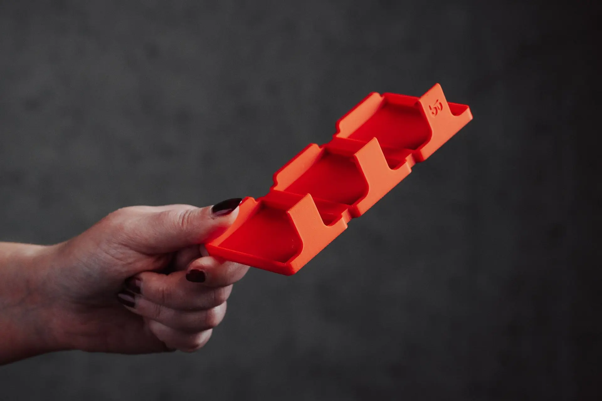 A hand holding an empty Hōld Trio model